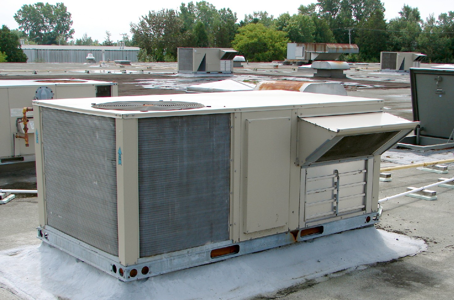 Commercial packaged heating and cooling units on a building rooftop.